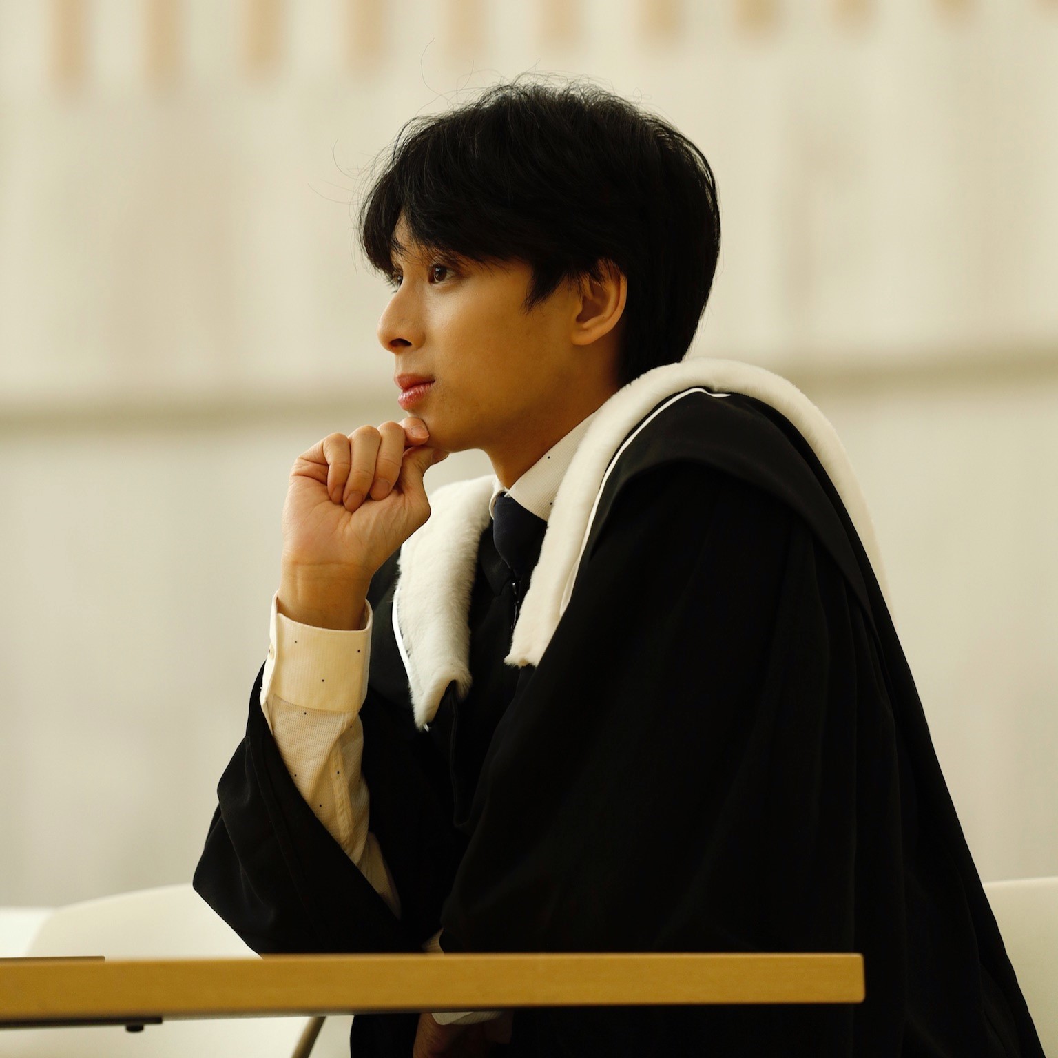 Wayne seated in gown
